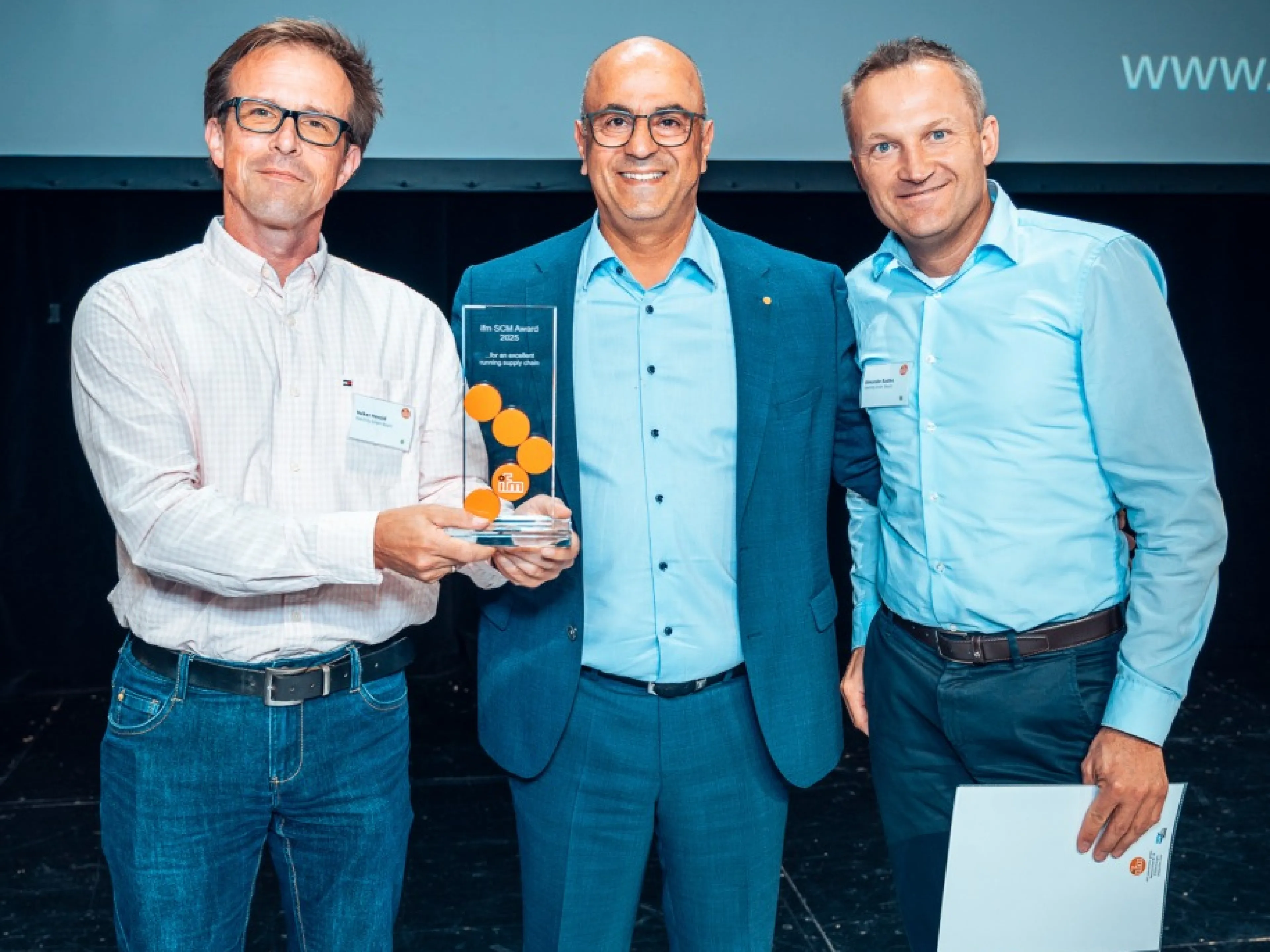 Bilgin Kilic (Mitte) vergibt den Ifm SCM Award für die schnellste Einführung an Volker Herold (l.) und Alexander Radtke (r.) von Keenfinity, einem Spin-off von Bosch Sicherheitssysteme