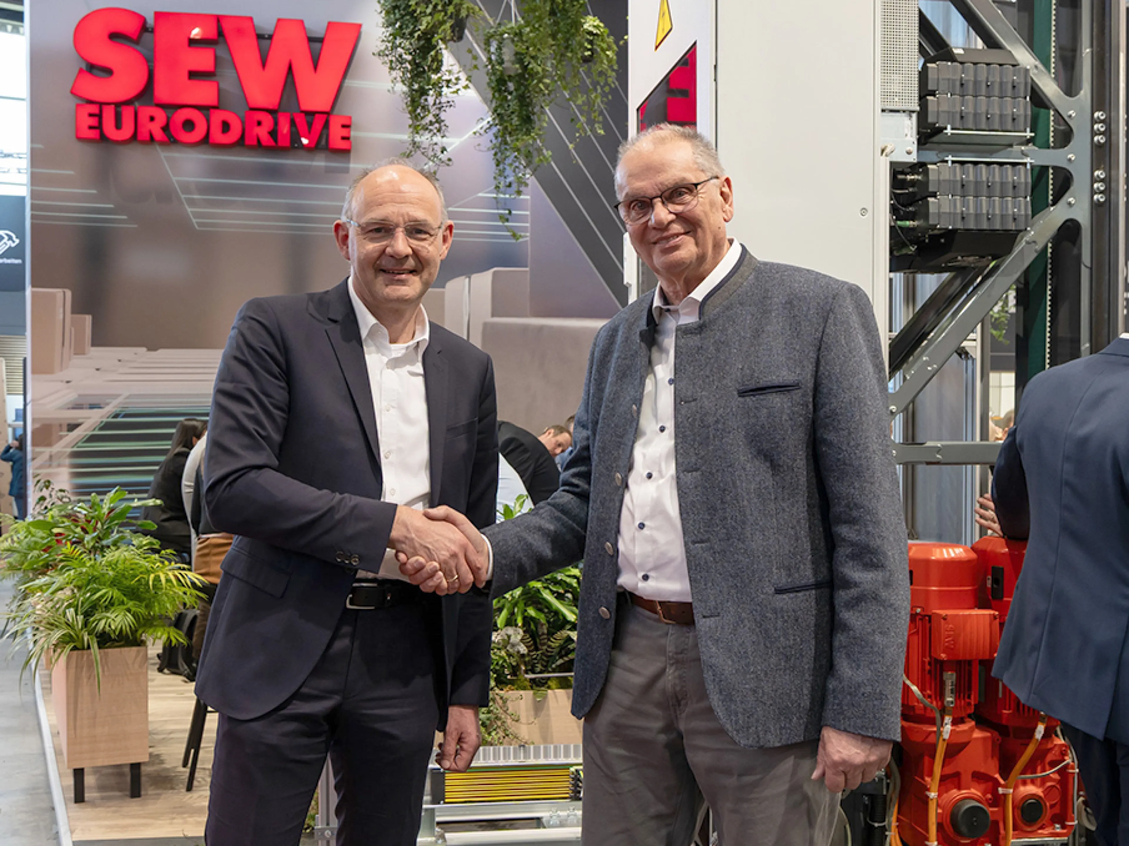 Dr. Hans Krattenmacher (li.) von SEW-Eurodrive und Michael Wolter (re.) von Safelog besiegeln auf der Logimat die Kooperation über ein gemeinsames Software-System