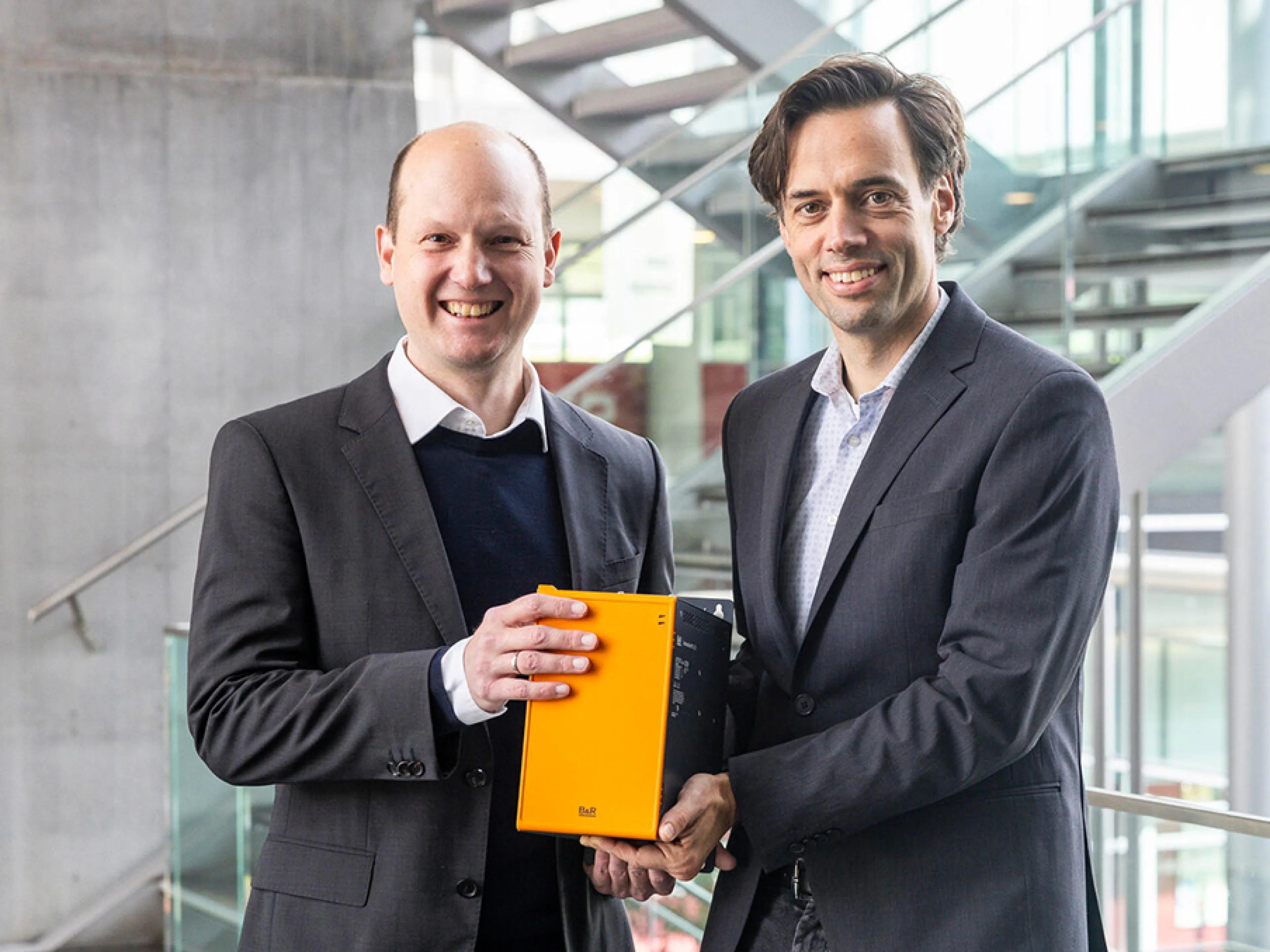 Stefan Huber (Head of Research, FH Salzburg) und Martin Haidacher (Innovation Manager, B&R) gemeinsam mit B&R Technik