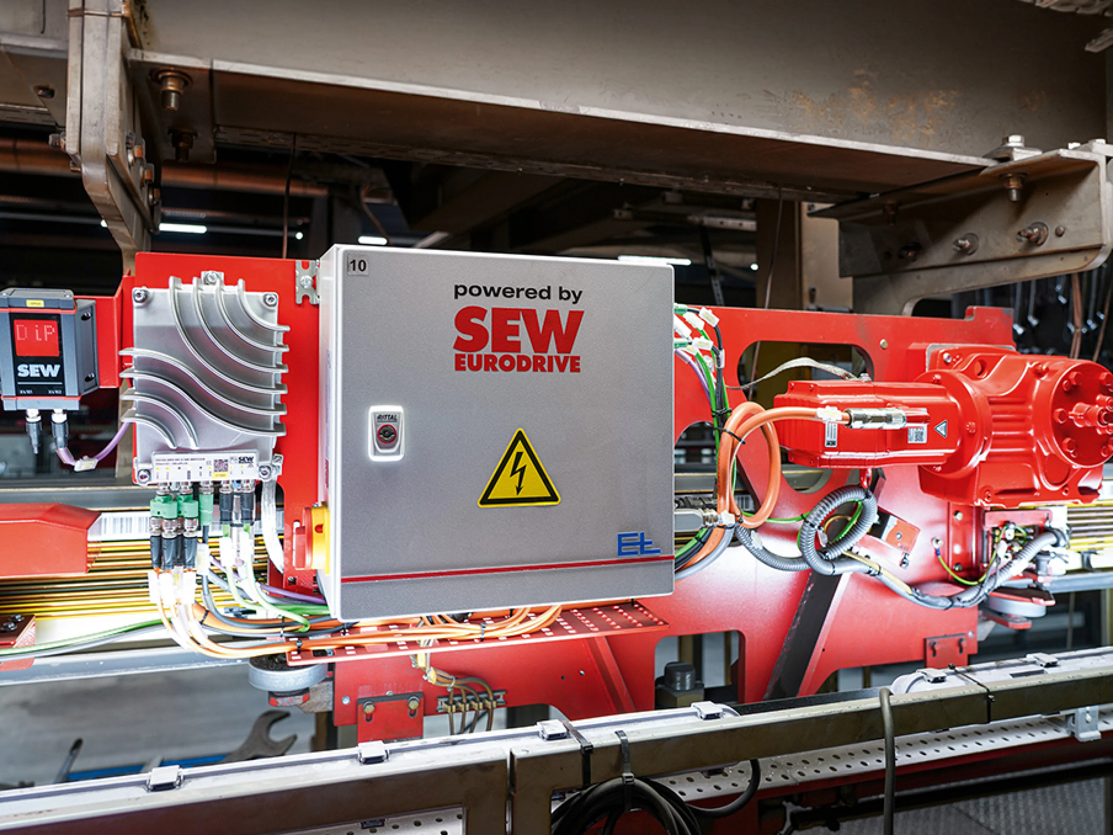 In der Decklackanlage der Elektrohängebahn von Kögel Trailer transportieren 18 EHB-Fahrzeuge die Trailer durch Lackierung, Trocknung und Abkühlung. Die neuen Komponenten von SEW-Eurodrive wurden so auf dem Fahrzeug angeordnet, dass sie sich ohne Einschränkungen in die vorhandene Anlagenstruktur einfügen