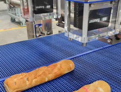2D-Profilsensor von Baumer: In der automatischen Sandwich-Linie liefert der smarte OXM unter anderem das benötigte Höhenprofil, hier zu sehen an der roten Laserlinie