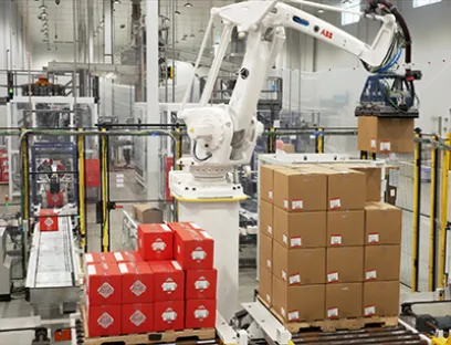 Der Palettierroboter nimmt abwechselnd Kartons von jedem Förderband auf und baut parallel separate Paletten für jede Produktgröße, Bild: ABB Palettierroboter IRB 660 von ABB