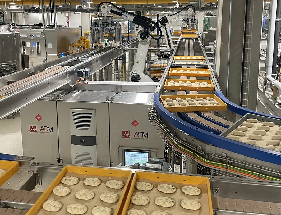 Zwei der vier „Motoman GP180“-Roboter entnehmen die Dielen am Frosterauslauf und setzen sie auf ein Förderband um, Bild: Yaskawa Zwei der vier „Motoman GP180“-Roboter von Yaskawa entnehmen die Dielen am Frosterauslauf und setzen sie auf ein Förderband um