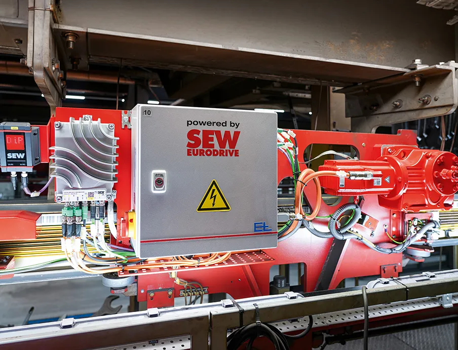 In der Decklackanlage der Elektrohängebahn von Kögel Trailer transportieren 18 EHB-Fahrzeuge die Trailer durch Lackierung, Trocknung und Abkühlung. Die neuen Komponenten von SEW-Eurodrive wurden so auf dem Fahrzeug angeordnet, dass sie sich ohne Einschränkungen in die vorhandene Anlagenstruktur einfügen