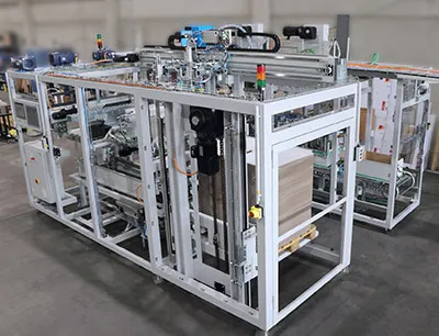 Der Deckelaufleger mit Kartonminimierung, Druck- und Etikettiereinrichtung ist U-förmig aufgebaut - vorn links die Deckelbearbeitung, hinten rechts die Kartonstrecke, Bild: SEW-Eurodrive Der Deckelaufleger mit Kartonminimierung, Druck- und Etikettiereinrichtung ist U-förmig aufgebaut
