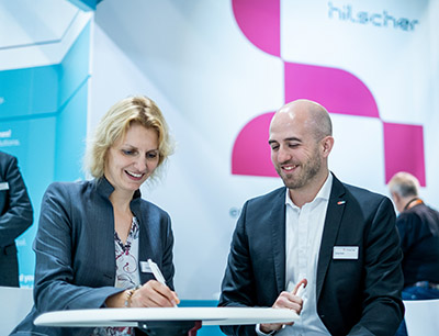 Birgit Stehlik, Director ISIE von Infoteam Software und Oliver Heidl, Vice President Partner Management bei Hilscher unterzeichnen den Kooperationsvertrag